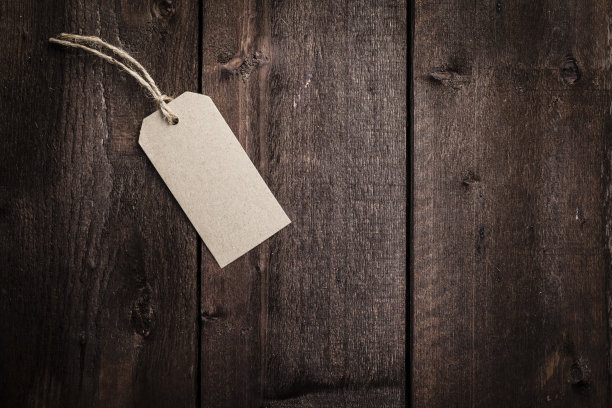 质朴的木桌上挂着带绳的棕色礼品标签图片下载