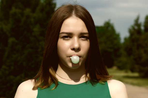 年轻漂亮的女孩嚼口香糖图片下载