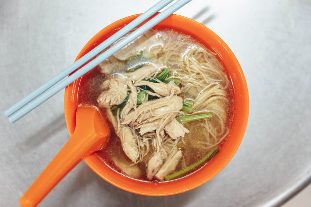 马来西亚吉隆坡的手工面条，里面有汤、鸡肉和肉汤。素材图片