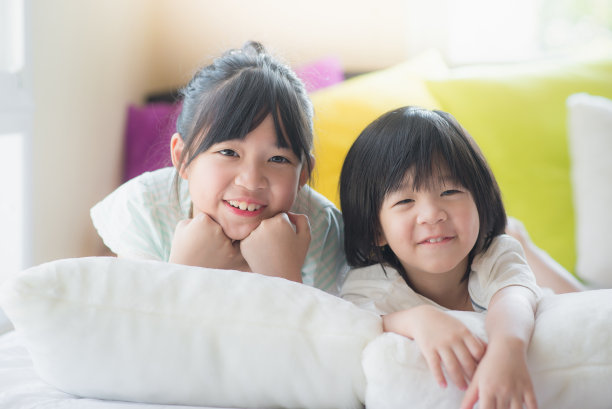 亚洲儿童躺在白色的床上图片下载