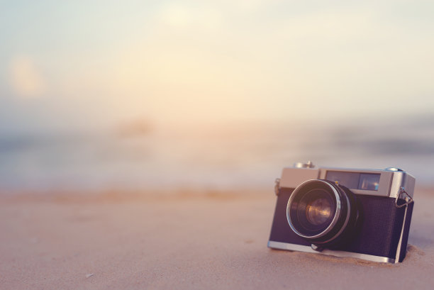 老式相机位于海滩上。图片下载