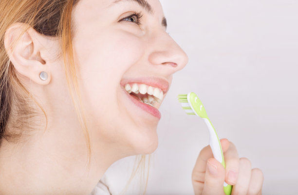 快乐的年轻女子正在刷牙。图片下载