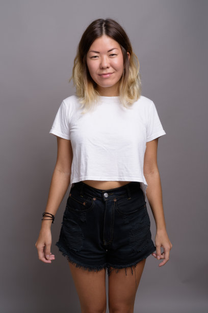 一名年轻的亚洲女子穿着白色衬衫，背景是灰色图片下载