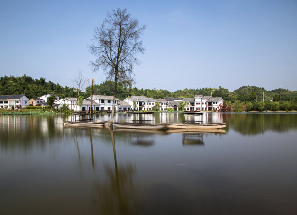 树、船和农舍倒映在水中图片下载