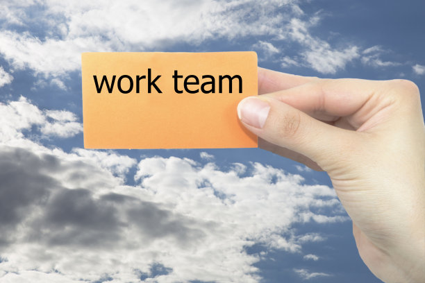 手握橙色名片书写工作团队。带有模糊背景的名片图片下载