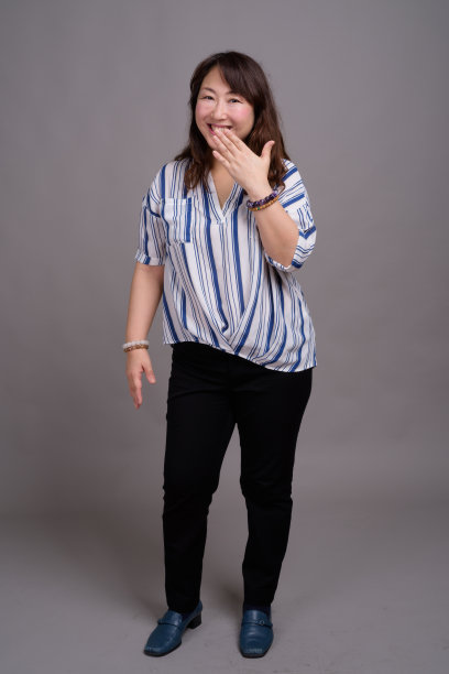 工作室拍摄的成熟美丽的亚洲女商人在灰色的背景图片下载
