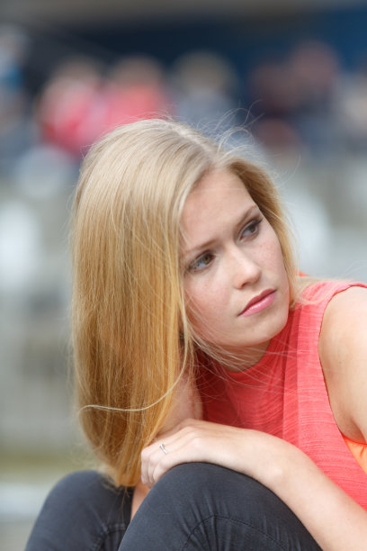 沉思的金发美女。垂直拍摄图片下载