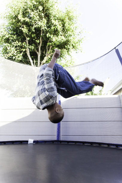 小男孩在蹦床上跳。图片下载