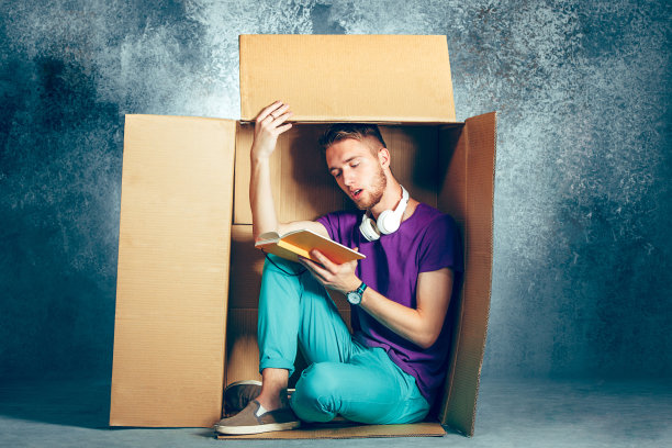 内向的人的概念。一个人坐在盒子里看书图片下载