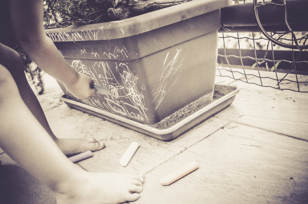 小男孩在地板上玩粉笔图片下载