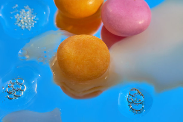 牛奶滴上橙色和粉色的糖果图片下载