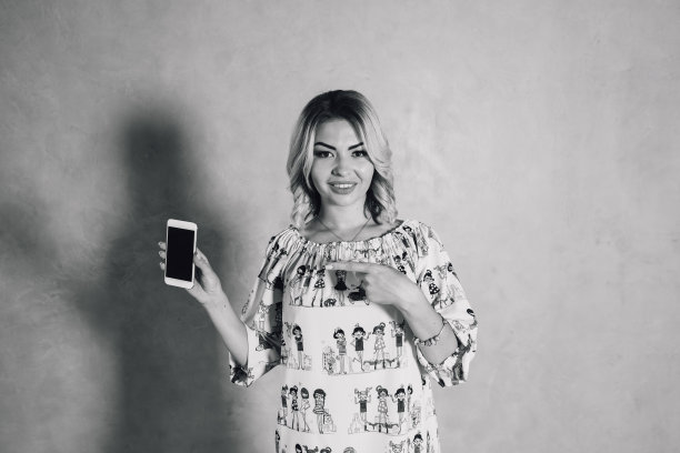 漂亮的年轻女子展示智能手机图片下载