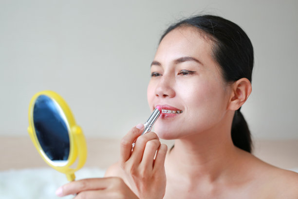 漂亮女人涂口红的肖像。美丽的概念。图片下载