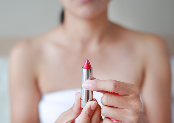 肖像美丽的女人打开口红。美丽的概念。图片下载