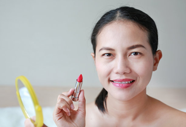 漂亮女人涂口红的肖像。美丽的概念。图片下载