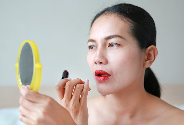 漂亮女人涂口红的肖像。美丽的概念。图片下载