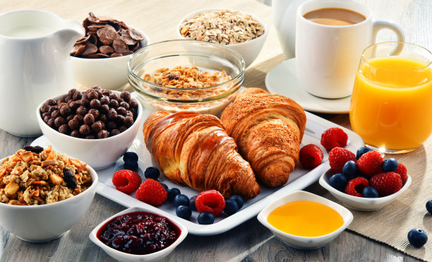 早餐配有咖啡、果汁、牛角面包和水果图片下载