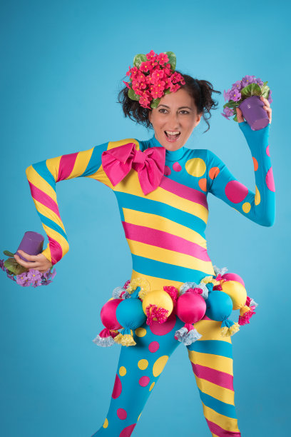 漂亮的年轻女人在化妆舞会上用糖果庆祝图片下载