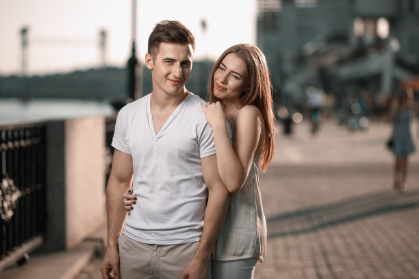 这是一对年轻情侣在城市里欣赏日落的照片图片下载