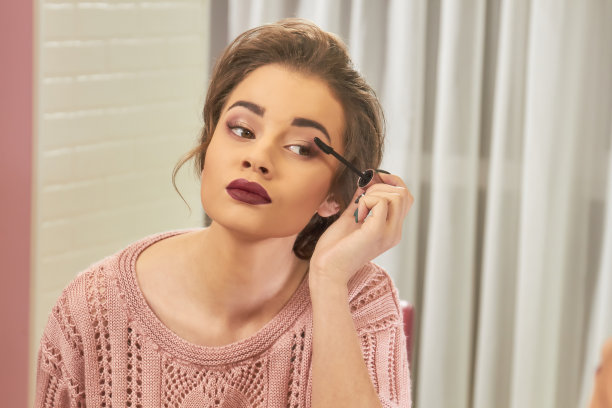 年轻女子用睫毛刷。图片下载