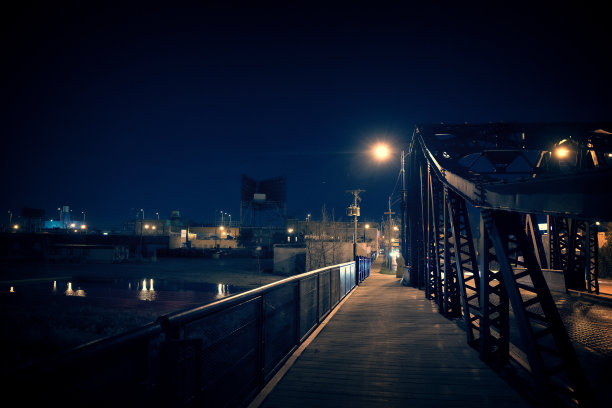 黑暗的芝加哥钢桥的夜晚。超现实的城市场景与散步在一个雇工用地旁边。图片下载