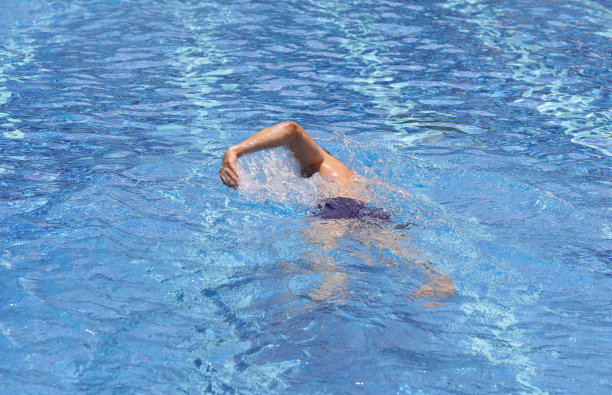 强壮的肌肉男子在游泳池爬泳式游泳。暑假很活跃。运动，健康的生活理念图片下载