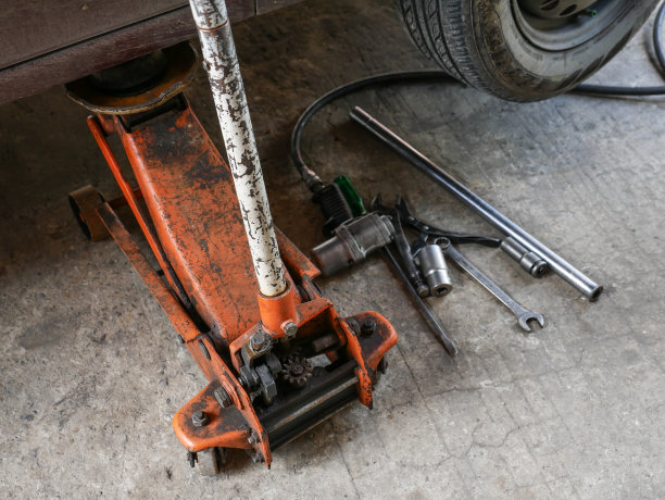 用汽车千斤顶工具吊起汽车进行维修图片下载