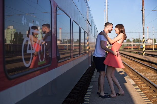 一对年轻夫妇在火车站放声大笑图片下载