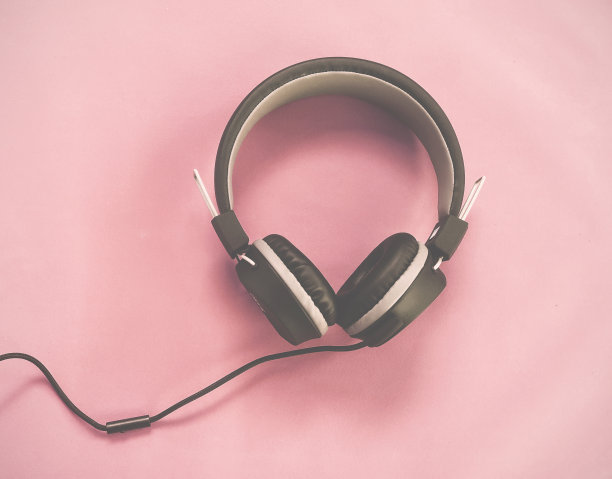 黑色耳机隔离粉色复古色调。素材图片