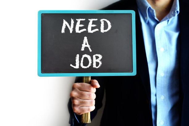 一个年轻人拿着一块写着“需要一份工作”的牌子图片下载