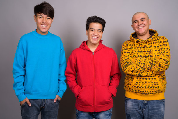 一群身穿保暖服装的亚洲年轻男士的影棚照片，灰色背景图片下载