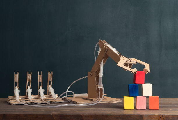 可爱的孩子发明了带有纸板的机器人手臂。素材图片