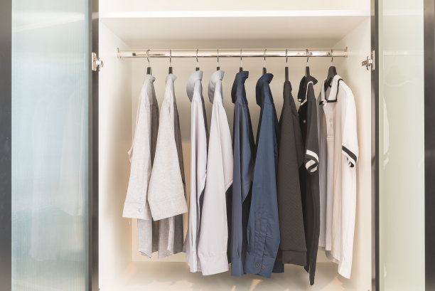 衣服挂在木制白色衣橱的栏杆上图片下载