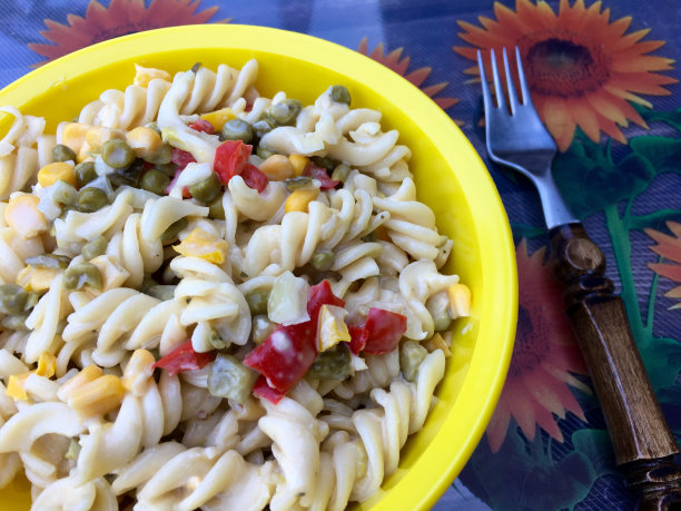 新鲜的面条沙拉，辣椒和玉米在一个黄色的碗图片下载