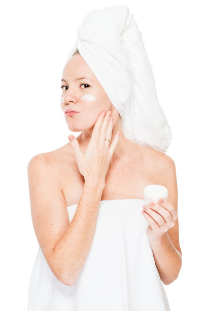 一个女人的皮肤上有雀斑，造成保湿霜在脸上孤立图片下载