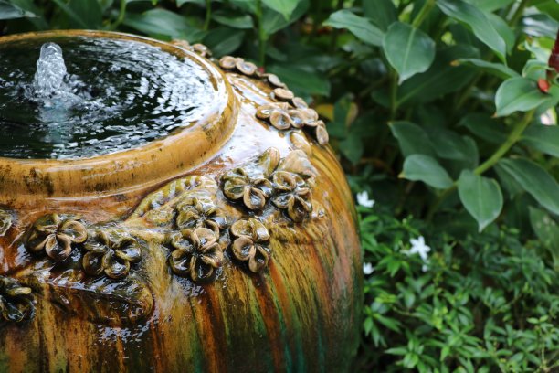 喷泉漂亮的坛子装饰在园林自然的树叶背景下图片下载