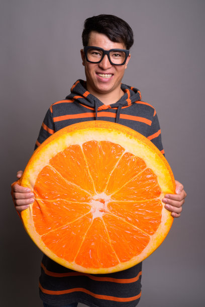 戴眼镜的年轻亚洲男子穿着连帽衫的棚拍照片图片下载