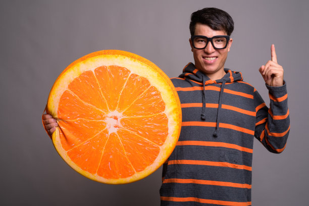 戴眼镜的年轻亚洲男子穿着连帽衫的棚拍照片图片下载