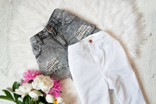灰色的短裤，白色的牛仔裤和牡丹白色皮毛。时尚的概念图片下载