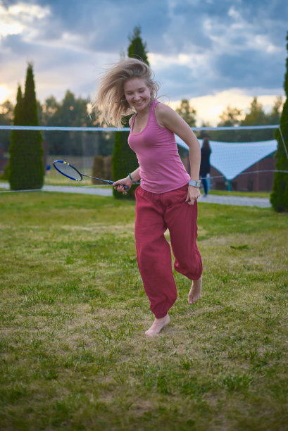 蓝色背景下拿着球拍的女孩。打羽毛球。运动。主动休息。图片下载