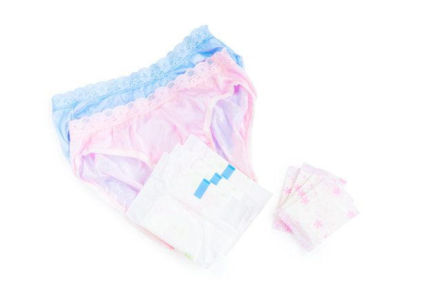 卫生巾和卫生巾堆在一起，粉红色和蓝色的女性内衣在白色的背景上，有复印空间图片下载