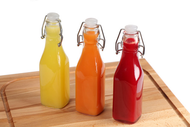 果汁装在玻璃瓶里，放在木板上图片下载