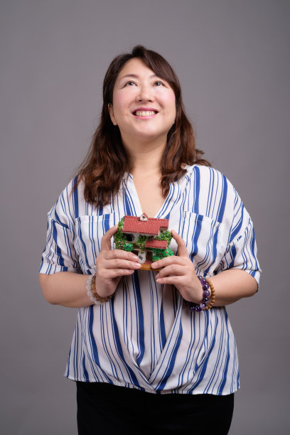 工作室拍摄的成熟美丽的亚洲女商人在灰色的背景图片下载