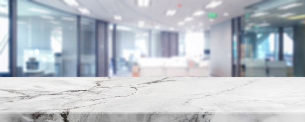 白色大理石桌面和模糊的散景办公室内空间背景-可以用来展示或蒙太奇您的产品。素材图片