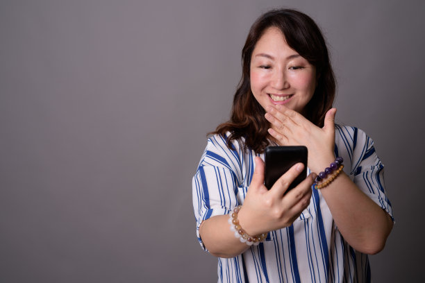 工作室拍摄的成熟美丽的亚洲女商人在灰色的背景图片下载