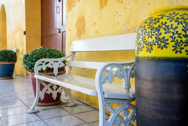 彩色墙壁前的白色复古花园长椅图片下载