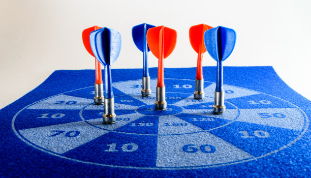 近距离的彩色飞镖在一个毛毡飞镖板图片下载