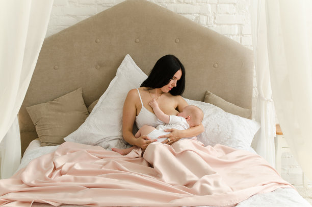 母乳喂养。年轻的母亲正在喂婴儿。家人在家里图片下载