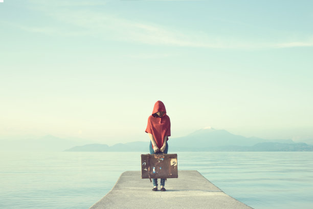 神秘的红衣女人把她的脸藏在一个施了魔法的湖里图片下载