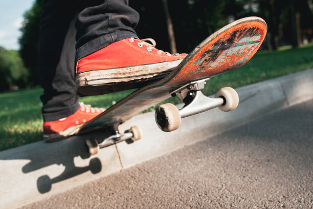 滑板运动员在公园做后滑动作图片下载